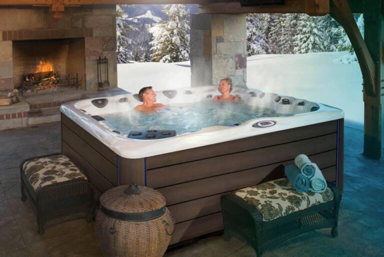 Two people enjoying a hot tub by a fire